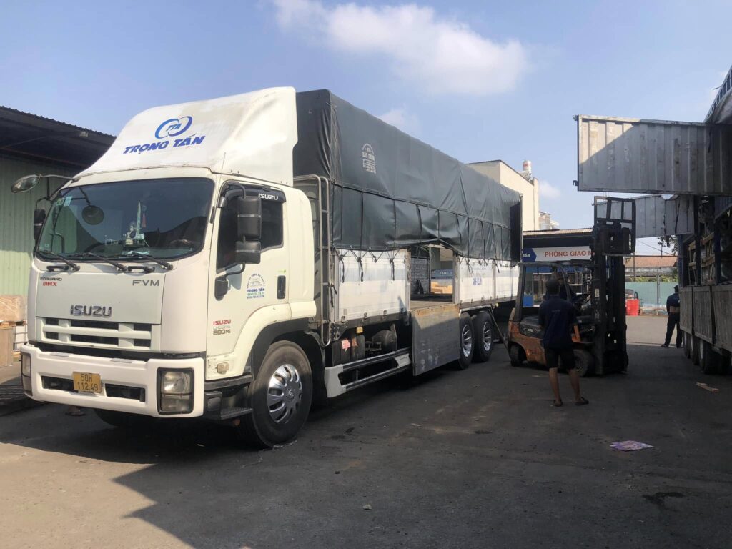 Nhân viên sử dụng xe nâng để sang hàng và chuyển tải hàng hóa lên xe tải 15 tấn giúp bốc xếp nhanh chóng an toàn và đúng quy trình. sang-hang-va-chuyen-tai-hang-hoa-bang-xe-nang-chuyen-nghiep-an-toan