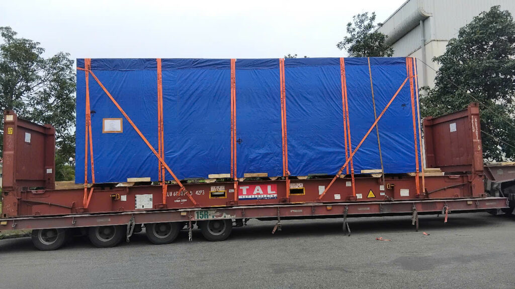 Nhân viên sử dụng dây tăng đơ và đai chằng để cố định các kiện lưới thép hàn trên mooc sàn trước khi vận chuyển từ Tây Ninh đi Quảng Ngãi. co-dinh-luoi-thep-han-tren-mooc-san-truoc-khi-van-chuyen-di-quang-ngai