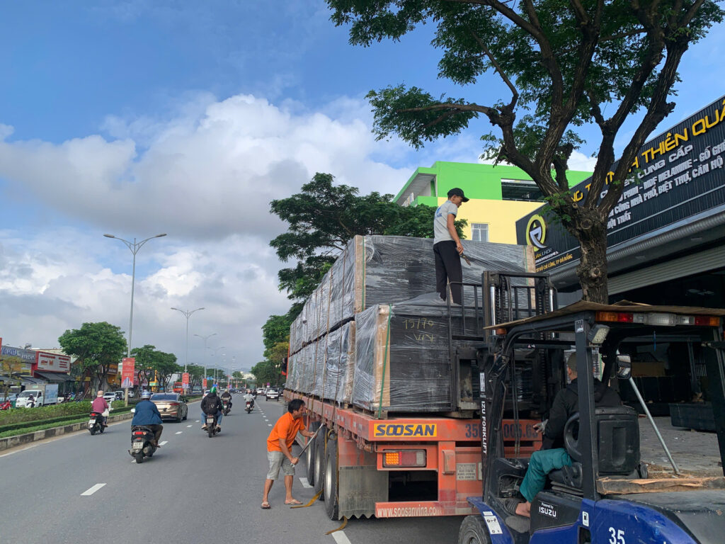 Xe đầu kéo mooc sàn giao ván phủ phim từ Vũng Tàu đi Kon Tum, sắp xếp hàng ngay ngắn và chằng buộc chắc chắn trước khi giao đến công trình. giao-hang-van-phu-phim-bang-xe-dau-keo-mooc-san-di-kon-tum