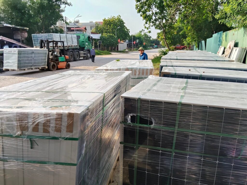 Xe đầu kéo mooc sàn vận chuyển tấm pin năng lượng mặt trời từ Bình Dương đi Bắc Giang, hàng hóa được sắp xếp và cố định cẩn thận trước khi khởi hành. xe-dau-keo-mooc-san-chuyen-cho-tam-pin-nang-luong-mat-troi-di-bac-giang